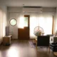 Unidad de aire acondicionado portátil 12000 BTU junto a una ventana en una sala de estar, imagen para el artículo "Aire acondicionado portátil 12000 BTU: claves para elegir bien"