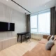 Televisor en pared con cinta métrica en un salón moderno para ilustrar cuanto mide un televisor de 43 pulgadas.