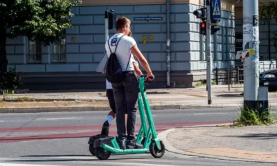 Persona circulando con un patinete no eléctrico por una acera junto a peatones