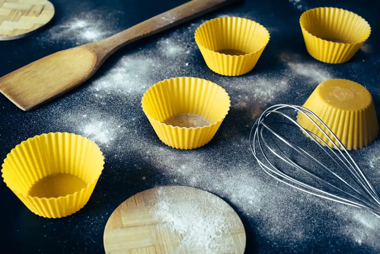 Moldes y recipientes para freidora de aire dentro de la cesta de una air fryer en una cocina doméstica