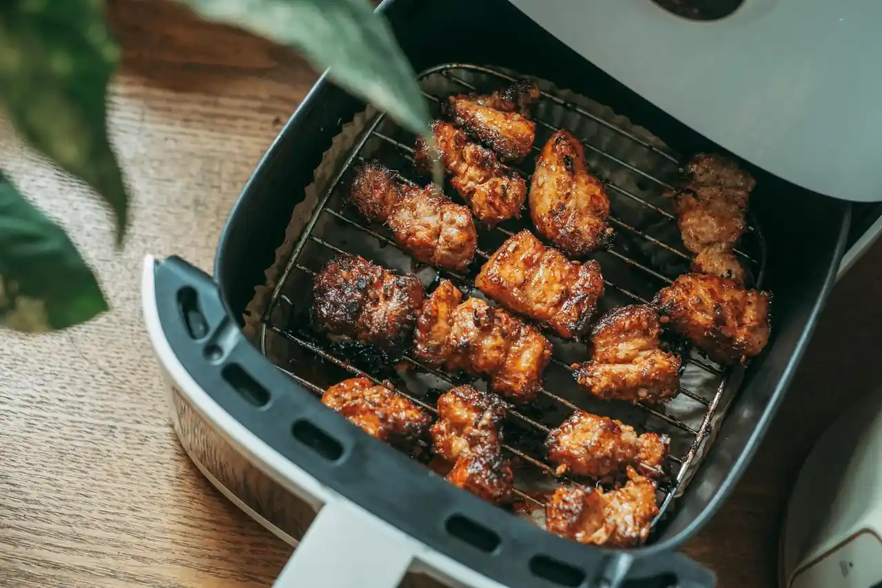 Imagen de una cocina moderna con electrodomésticos inteligentes, destacando un air fryer en la encimera.