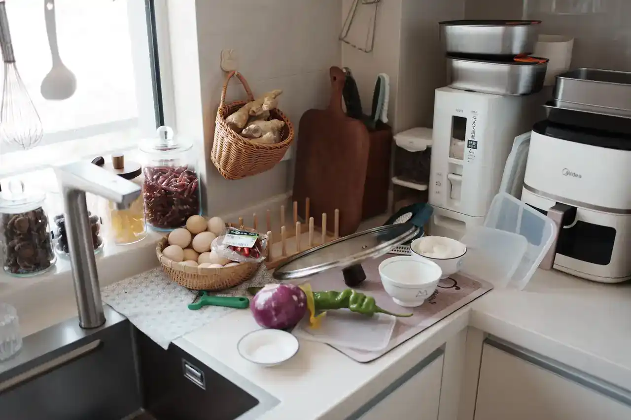Foto de una freidora de aire gasta mucha luz con un medidor de consumo eléctrico y una calculadora en la cocina
