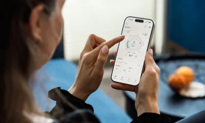 Aire acondicionado portátil blanco en una sala contemporánea con control remoto y smartphone a un lado, imagen para ilustrar el artículo Cuál es el mejor aire acondicionado portátil en 2026.