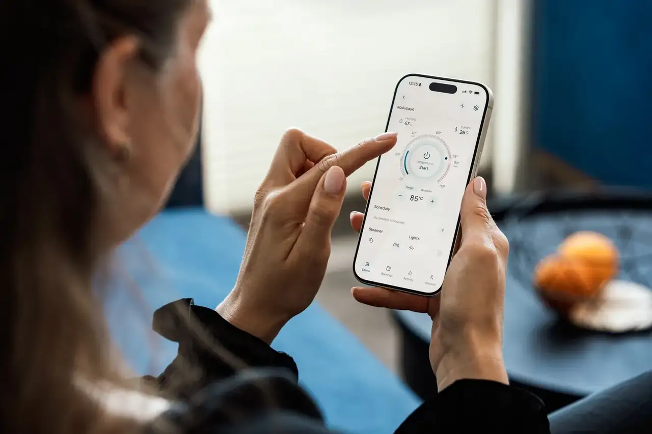 Aire acondicionado portátil blanco en una sala contemporánea con control remoto y smartphone a un lado, imagen para ilustrar el artículo Cuál es el mejor aire acondicionado portátil en 2026.