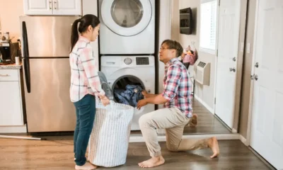 Armario para lavadora y secadora: cómo elegir el mueble ideal — lavandería moderna con un mueble empotrado que oculta lavadora y secadora de carga frontal, encimera para doblar ropa y cestas organizadoras.