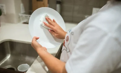 Imagen para el artículo como limpiar el lavavajillas con finish: una persona limpia el interior del lavavajillas en una cocina moderna.