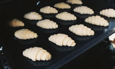 Mujer limpiando el horno con bicarbonato y vinagre en la cocina, en una imagen útil para explicar como limpiar horno con bicarbonato y vinagre sin dañarlo.