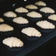 Mujer limpiando el horno con bicarbonato y vinagre en la cocina, en una imagen útil para explicar como limpiar horno con bicarbonato y vinagre sin dañarlo.