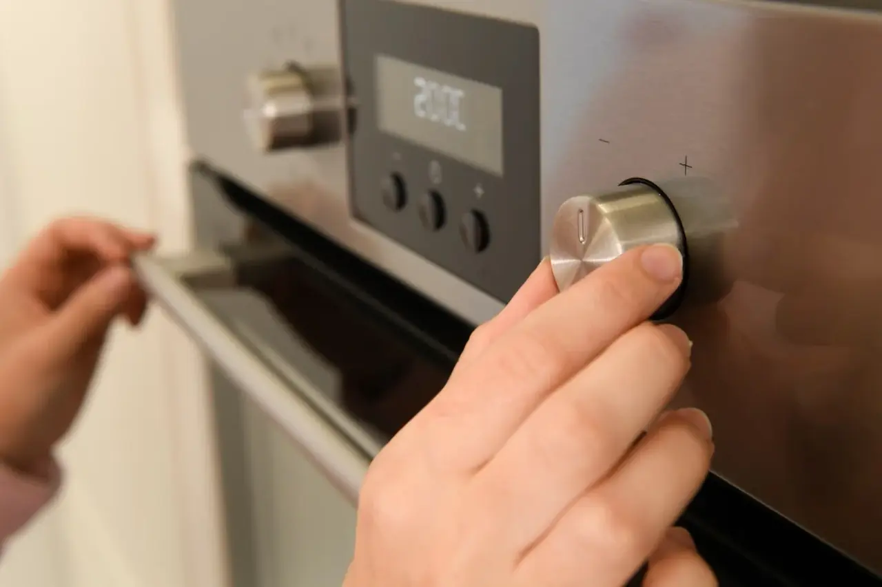 Mano ajustando la ruleta de temperatura de un frigorífico para regular la temperatura frigorífico 1 a 7