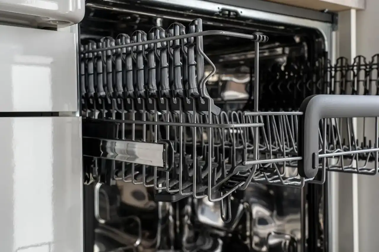 Lavavajillas fagor innovation como funciona: interior de un lavavajillas abierto con platos y brazos rociadores visibles en una cocina moderna.