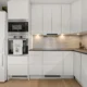 Cocina moderna con frigorificos panelables de colores integrados en los muebles y una puerta verde mate