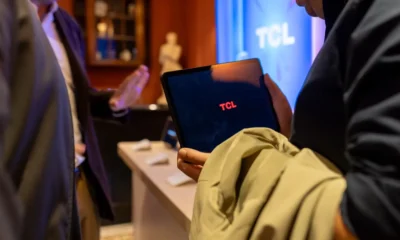 Clientes comparando televisores de gran formato en un showroom de electrónica, imagen ilustrativa para Media Markt televisor 65 pulgadas: guía para acertar en tu compra
