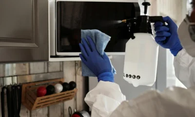 Imagen de una persona limpiando un microondas muy sucio en la cocina, ideal para explicar como limpiar el microondas muy sucio sin dañar el aparato.