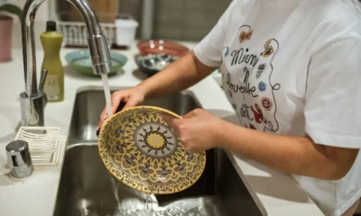 Persona cargando un lavavajillas abierto con platos limpios, imagen para el artículo Cuánta agua gasta un lavavajillas y qué factores cambian el consumo