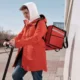 Persona revisando una multa pendiente junto a un patinete eléctrico