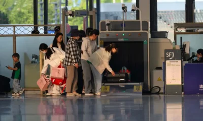 Patinete elétrico dobrado ao lado de uma mala no aeroporto antes do embarque