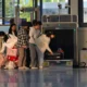 Patinete elétrico dobrado ao lado de uma mala no aeroporto antes do embarque