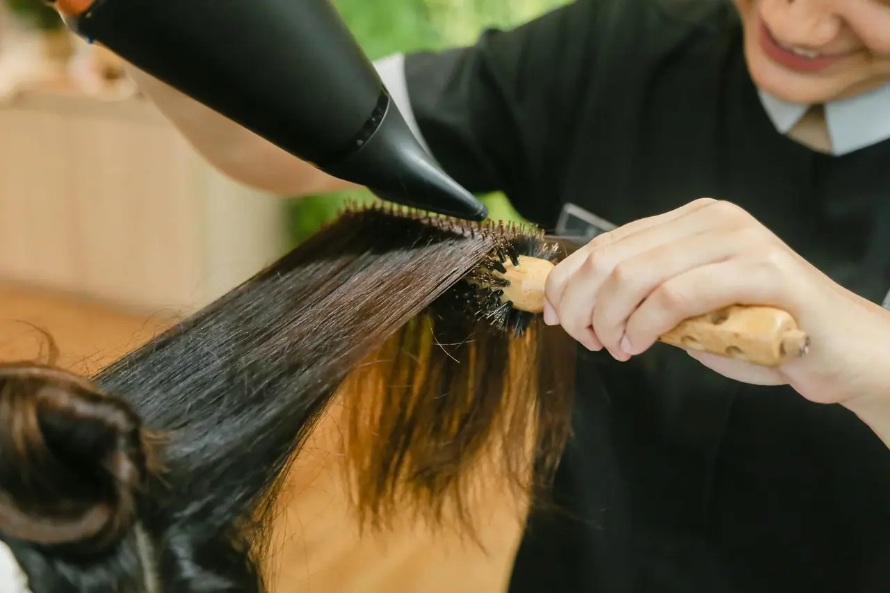 Secadores de pelo profesionales de peluquería en un salón de belleza mientras se realiza el secado del cabello.