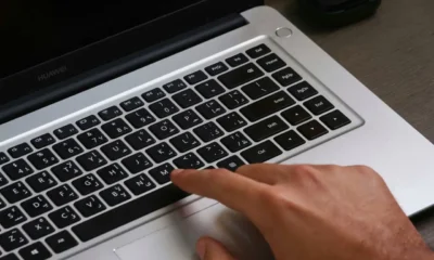 Mano revisando el panel táctil de una placa Balay con un aviso de funcionamiento