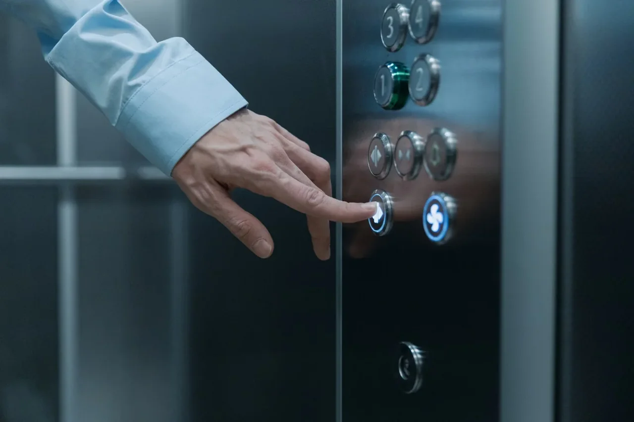 Primer plano de una mano pulsando el panel de control de una nevera, ilustrando el artículo Panel de control nevera Haier: funciones, ajustes y fallos.