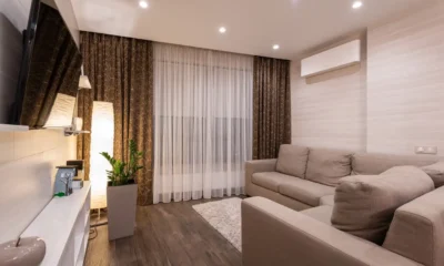 Persona limpiando un filtro de aire acondicionado en casa, ilustrando como limpiar filtros aire acondicionado paso a paso.