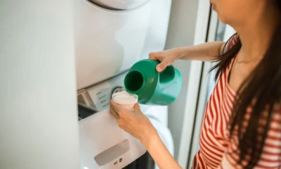 Botella de detergente casero junto a una lavadora para ilustrar como hacer jabon liquido para lavadora