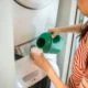 Botella de detergente casero junto a una lavadora para ilustrar como hacer jabon liquido para lavadora