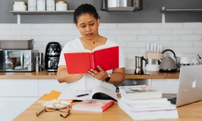 Una persona en la cocina leyendo manuales de electrodomésticos