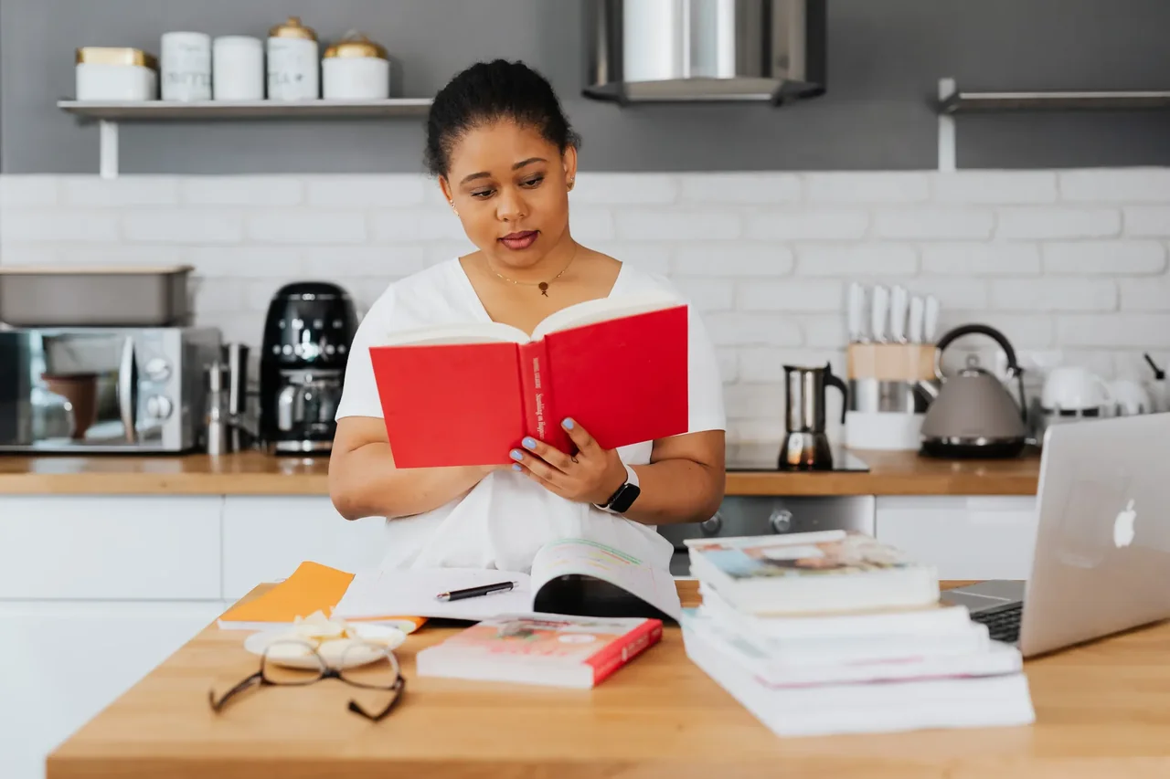 Una persona en la cocina leyendo manuales de electrodomésticos