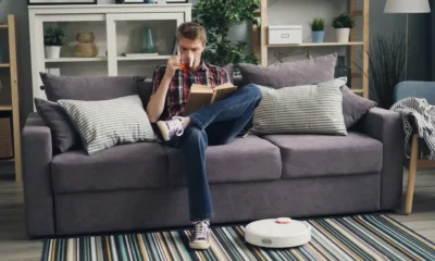 Ilife robot aspirador A30 Pro: análisis completo y precio real — Ilife A30 Pro en funcionamiento sobre suelo de madera junto a un sofá en una sala de estar moderna.