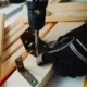 Instalación de un soporte de pared para televisores en una sala de estar con herramientas y cinta métrica.