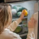 Interior de frigorífico abierto con termómetro digital que marca 4°C y congelador en -18°C, ilustrando Temperatura ideal del frigorífico y congelador: guía práctica
