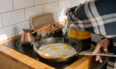 Purificador de aire moderno sobre la encimera junto a la placa con vapor de cocina; imagen para Cómo elegir un purificador para eliminar los olores de cocina que muestra ubicación, tamaño y diseño recomendados.