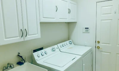 mueble para lavadora y secadora en un lavadero moderno con lavadora y secadora apiladas dentro de un armario blanco
