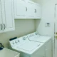 mueble para lavadora y secadora en un lavadero moderno con lavadora y secadora apiladas dentro de un armario blanco
