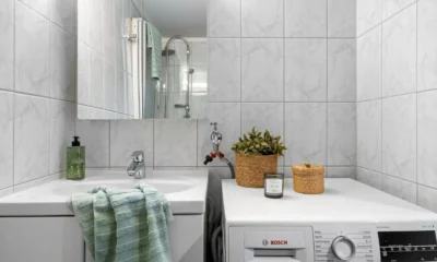 Foto de una lavadora Bosch en casa con una mano pulsando el panel para ilustrar como resetear lavadora bosch