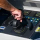 Manos presionando el panel de control de un lavavajillas en una cocina moderna, imagen ilustrativa para Cómo reiniciar un lavavajillas Beko sin dañar el equipo