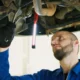 Mecánico revisando una rampa inyeccion en el motor de un coche