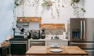 Medidor de consumo enchufable junto a un frigorífico en una cocina, ilustrando Cuánto consume un frigorífico por hora: cifras reales y ahorro
