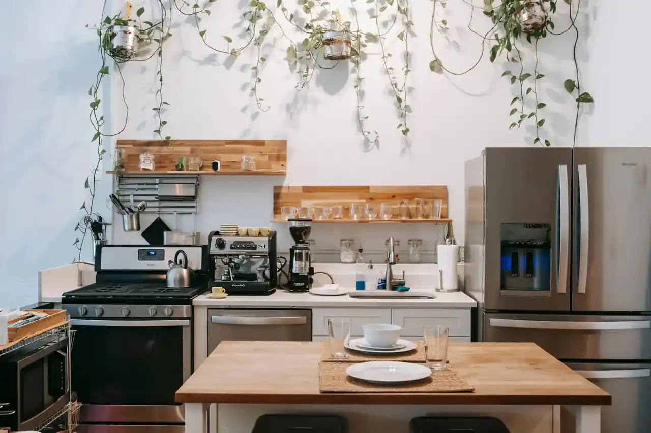 Medidor de consumo enchufable junto a un frigorífico en una cocina, ilustrando Cuánto consume un frigorífico por hora: cifras reales y ahorro