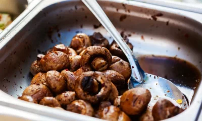 Horno de vapor combinado abierto, con vapor visible y verduras asadas en una bandeja, una imagen que explica que es un horno de vapor combinado.