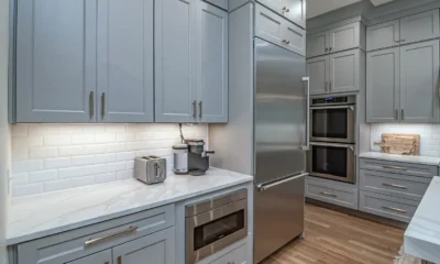 Columna horno microondas junto frigorifico en una cocina moderna con muebles integrados y frigorífico al lado