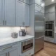 Columna horno microondas junto frigorifico en una cocina moderna con muebles integrados y frigorífico al lado