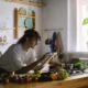Robot de cocina mas vendido en una cocina moderna, junto a una pantalla con recetas y varios ingredientes preparados.