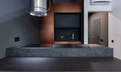 Cocina moderna con campana extractora downdraft encimera elevada detrás de una placa de inducción.