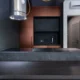 Cocina moderna con campana extractora downdraft encimera elevada detrás de una placa de inducción.