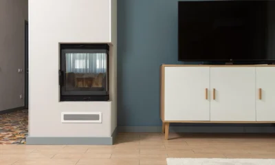 Salón moderno con mueble de televisor con chimenea eléctrica integrada y pantalla encima