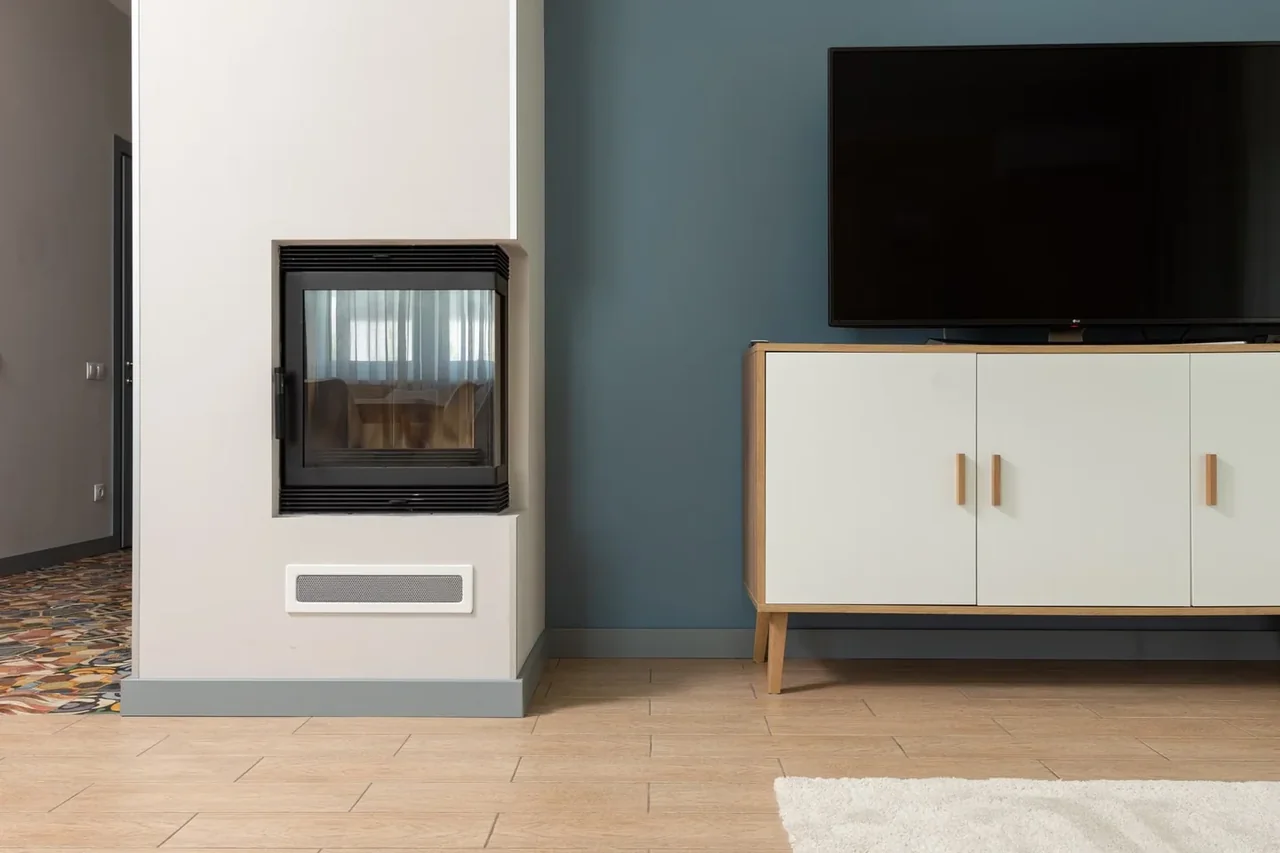 Salón moderno con mueble de televisor con chimenea eléctrica integrada y pantalla encima