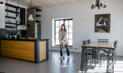 Persona limpiando el suelo de una cocina moderna con un aspirador escoba friegasuelos en modo seco y húmedo — imagen para Aspirador escoba friegasuelos en seco y húmedo: guía de compra.