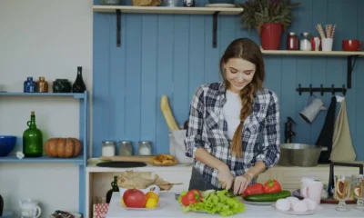 Robot de cocina multifunción Moulinex en una cocina moderna, con una persona usando la pantalla táctil para seguir una receta guiada.